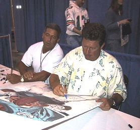 Dan Marino signing the sports painting of him done by Sports Artist Stephen Marotta